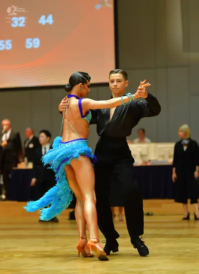 Dancesport competitor: Female dancer: light blue Latin dance costume with long blue fringe and thin str