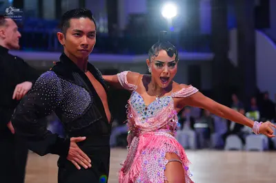 Dancesport competitor: Male dancer: black Latin dance top with silver sequins and black trousers