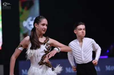 Dancesport competitor: Female dancer: white Latin dance dress with leopard print accents, white fringe,