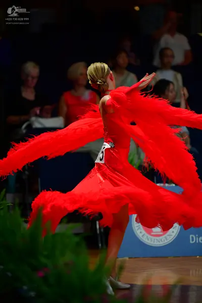 Dancesport competitor: Female dancer: red latin dress with long feathery fringe