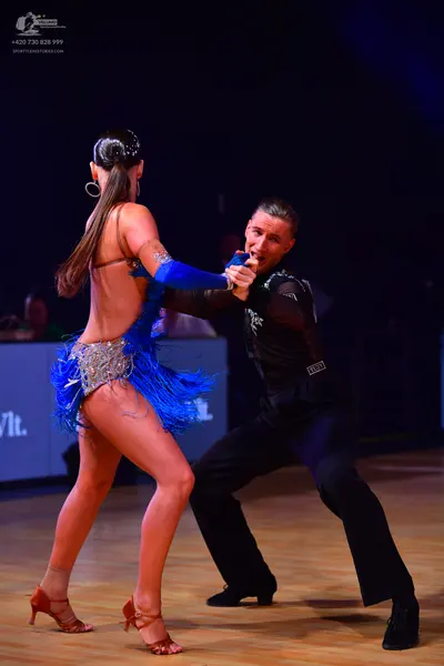 Dancesport competitor: Female dancer: blue Latin dress with blue fringe and silver/sequined embellishme