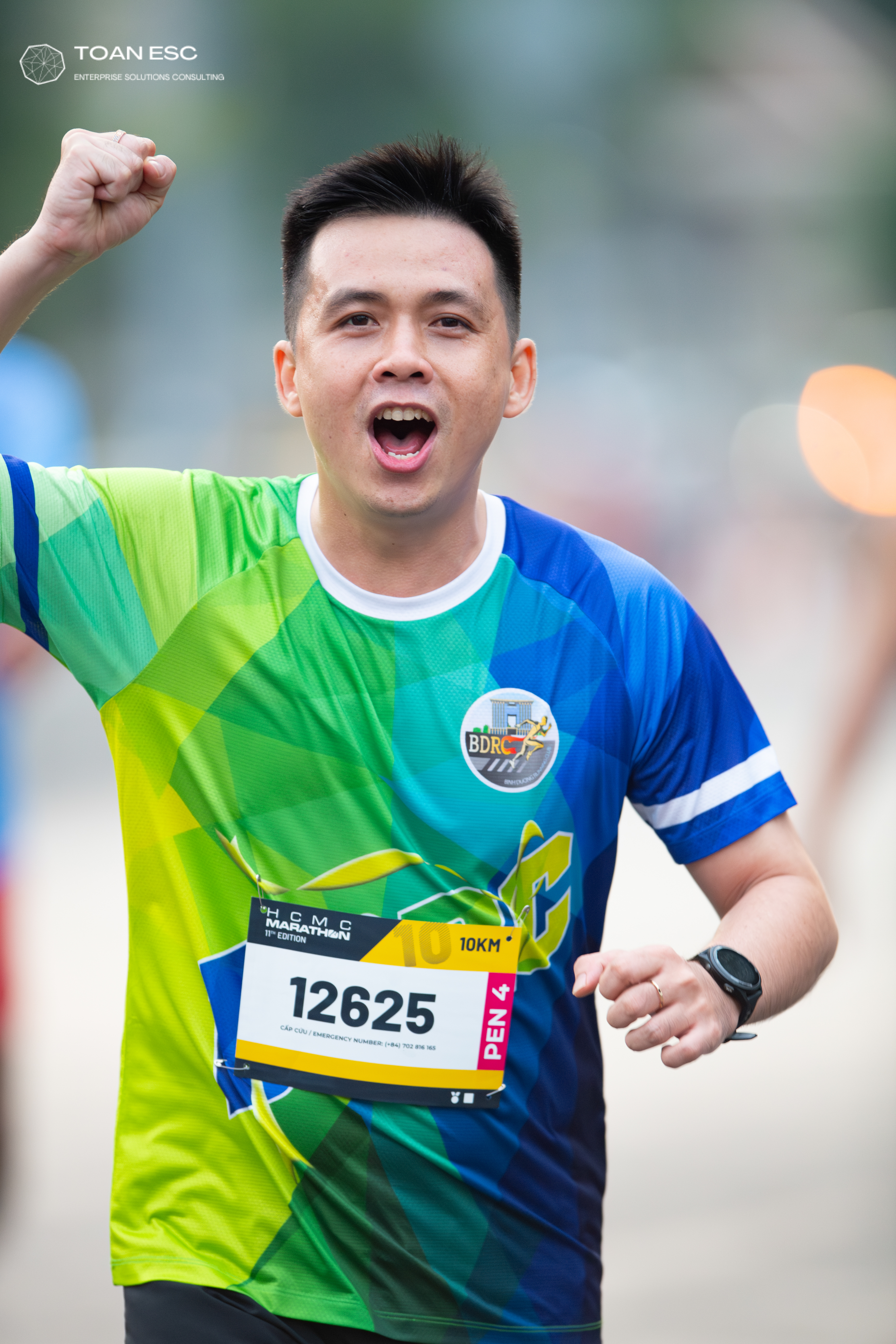 Marathon runner #12625: Runner 1: lime green and blue patterned jersey, black shorts, black smartwatch