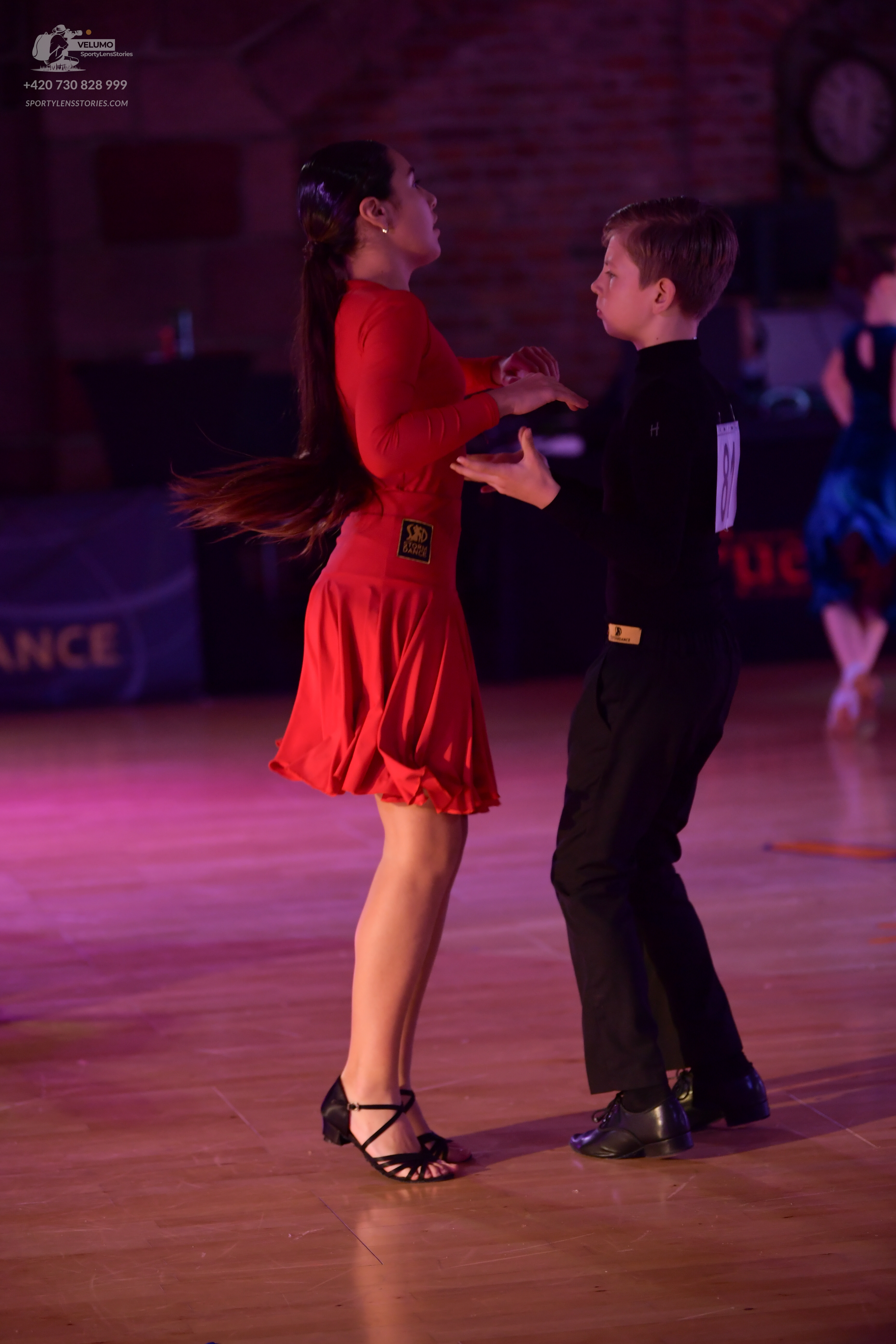 Dancesport competitor: Female dancer: red long-sleeved Latin dress