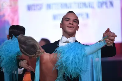 Dancesport competitor: Male dancer: black suit with a white shirt and white bow tie