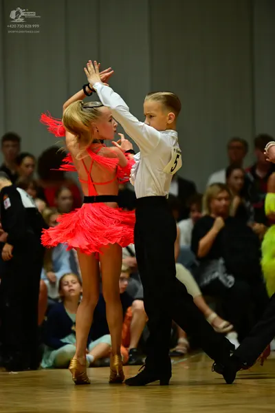 Dancesport competitor: Female dancer: bright red Latin dress with fringe
