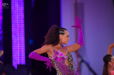 Dancesport competitor: Female dancer: leopard print Latin dress with purple sequin embellishments and a