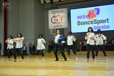 Dancesport competitor: All female dancers: white long-sleeved shirts and black pants