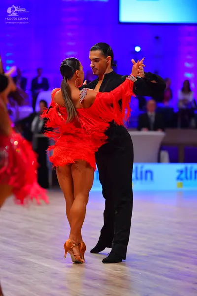 Dancesport competitor: Female dancer: red Latin dress with long fringe
