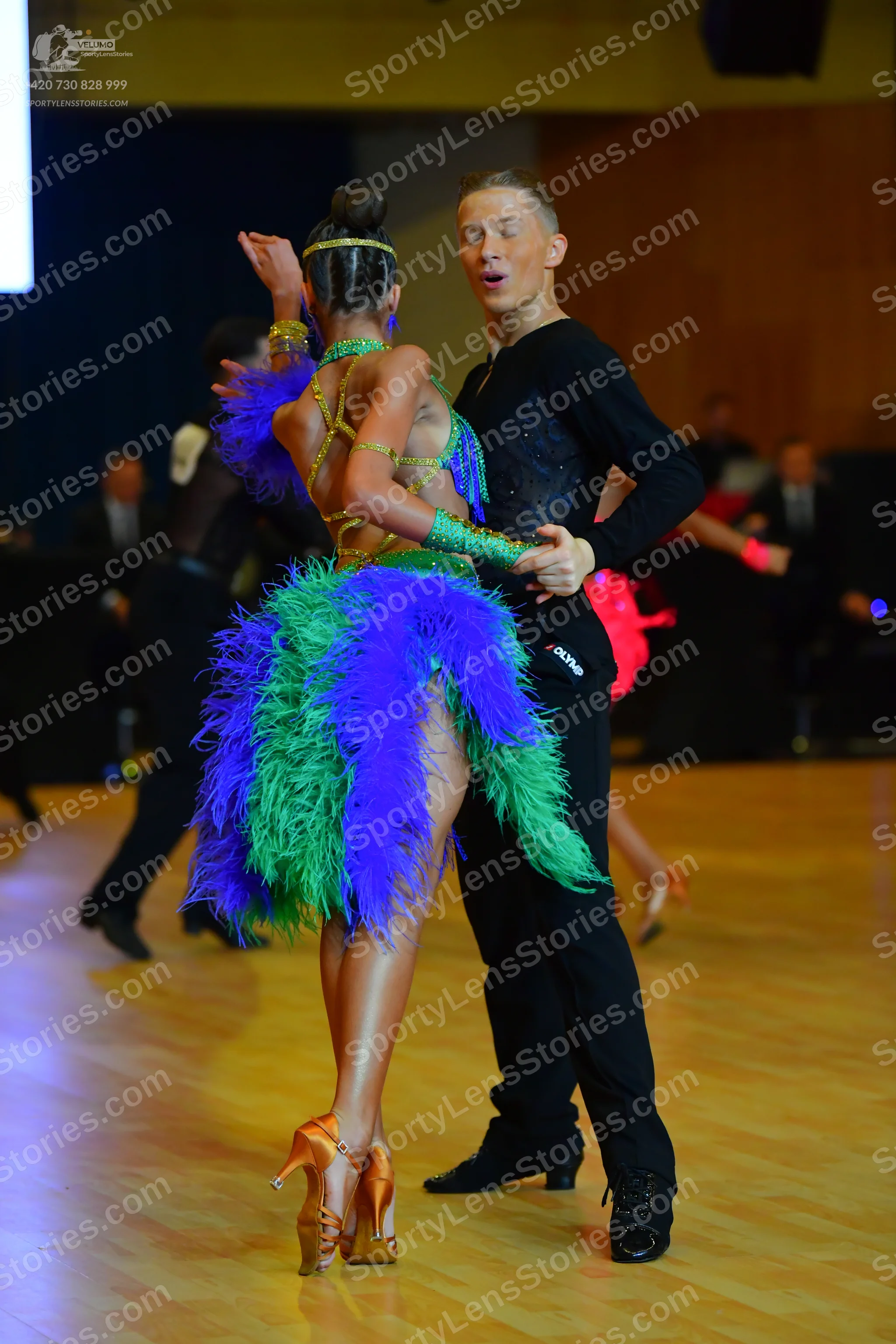 Dancesport competitor: Male dancer: black long-sleeved form-fitting top and black trousers with black d