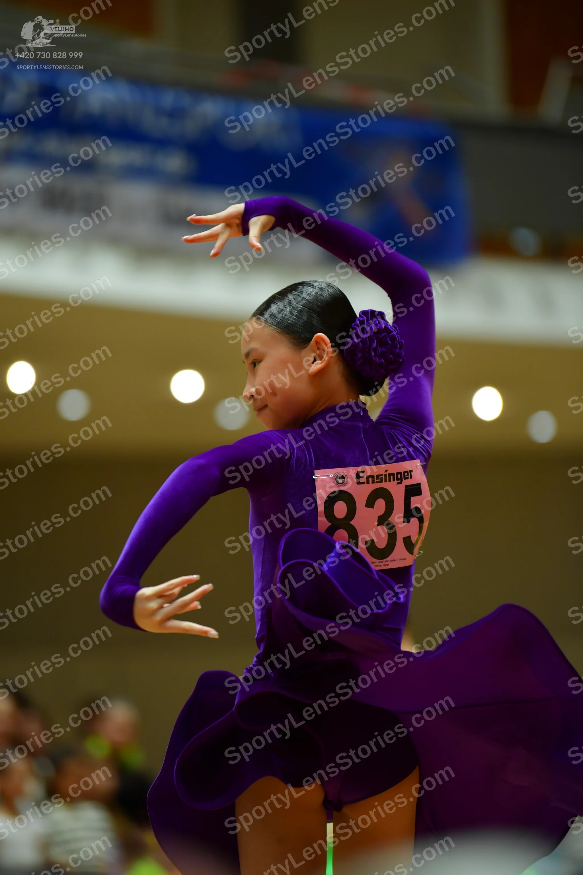 Dancesport competitor #835: Female dancer: purple long-sleeved latin dress with a large, flowing skirt and a