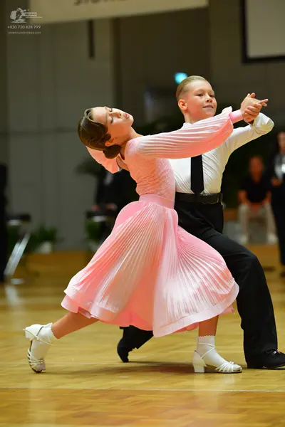 Dancesport competitor: Female dancer: light pink long-sleeved ballroom dress with a pleated skirt
