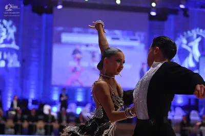 Dancesport competitor: Female dancer: black latin dress with silver sequins and thin straps, wearing si