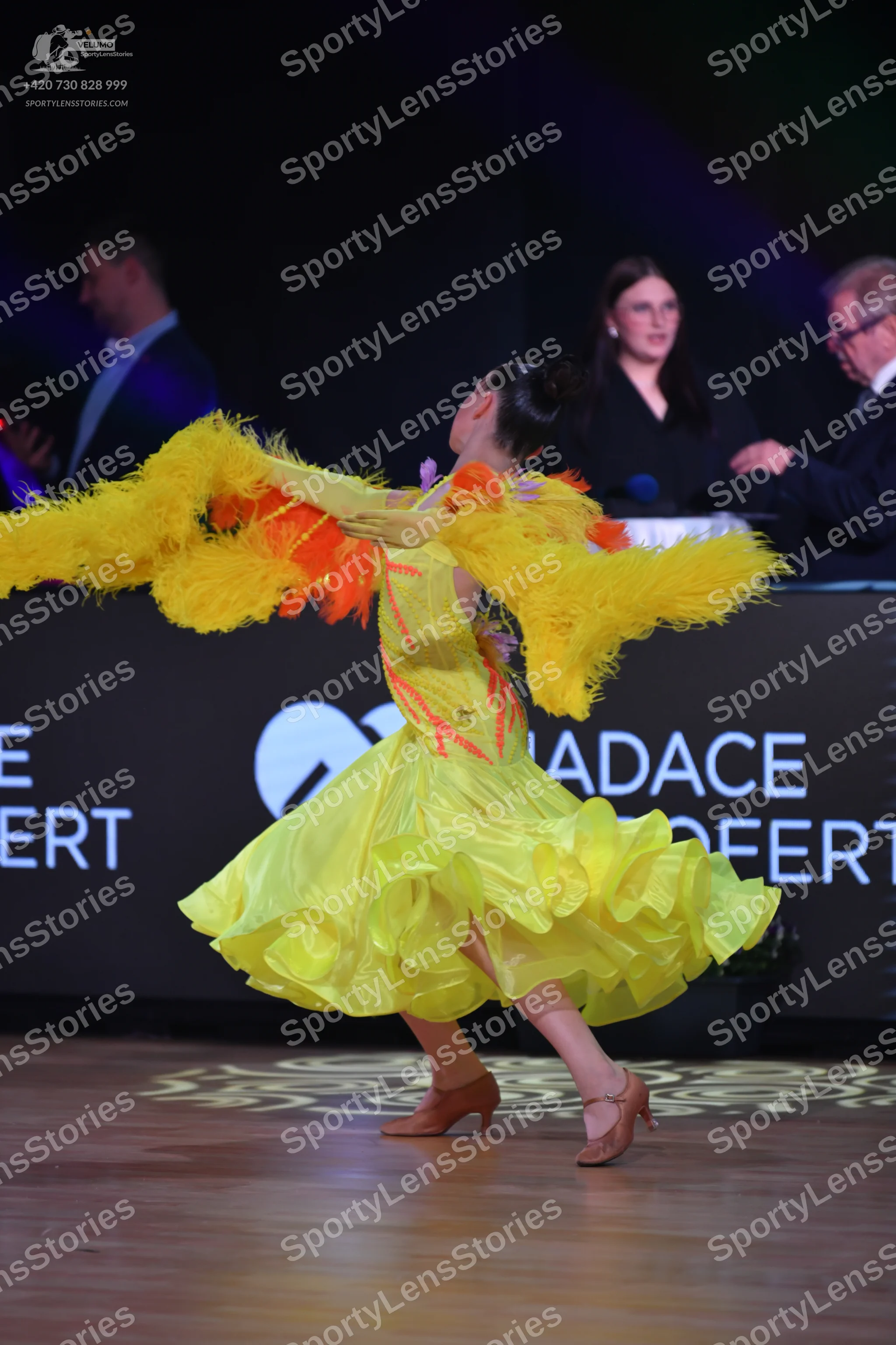 Dancesport competitor: Female dancer: bright yellow Latin dance dress with a voluminous, ruffled skirt