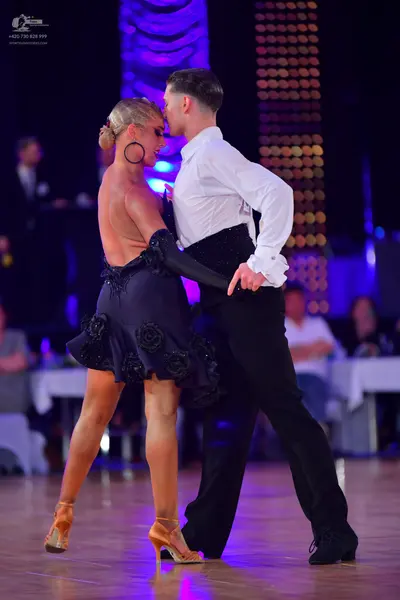 Dancesport competitor: Male dancer: white long-sleeved shirt with ruffled cuffs and black trousers