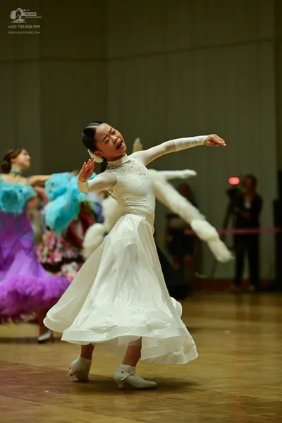 Dancesport competitor: ** White Latin dress
*   **Fabric:** Satin, likely with a slight sheen