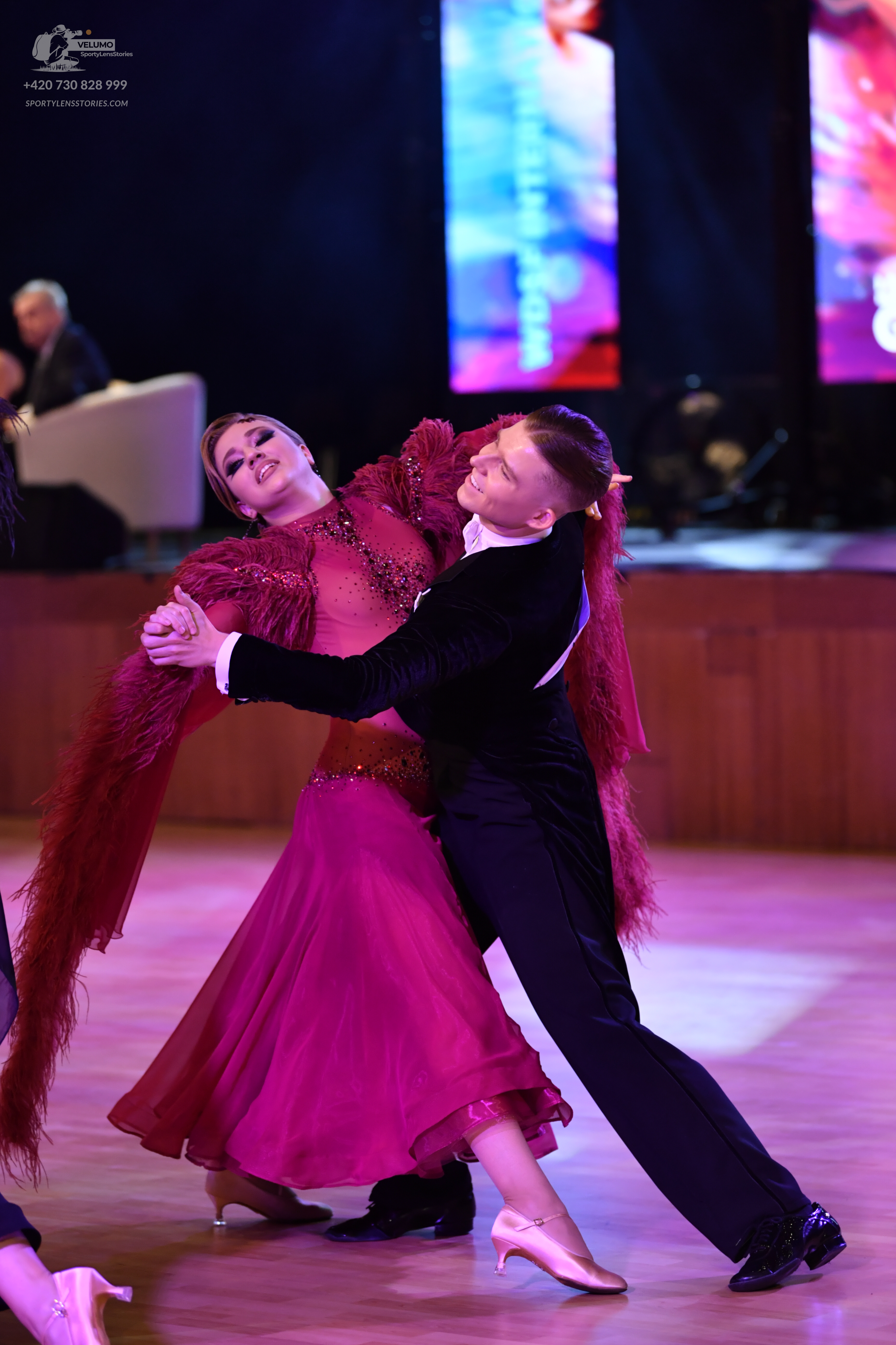 Dancesport competitor: Female dancer: deep red ballroom dress with a beaded bodice and long fringe on t