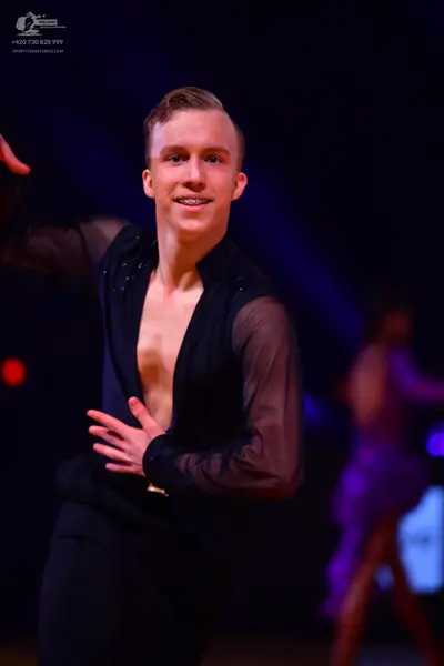 Dancesport competitor: Male dancer: black shirt with sheer sleeves and small embellishments, and black 