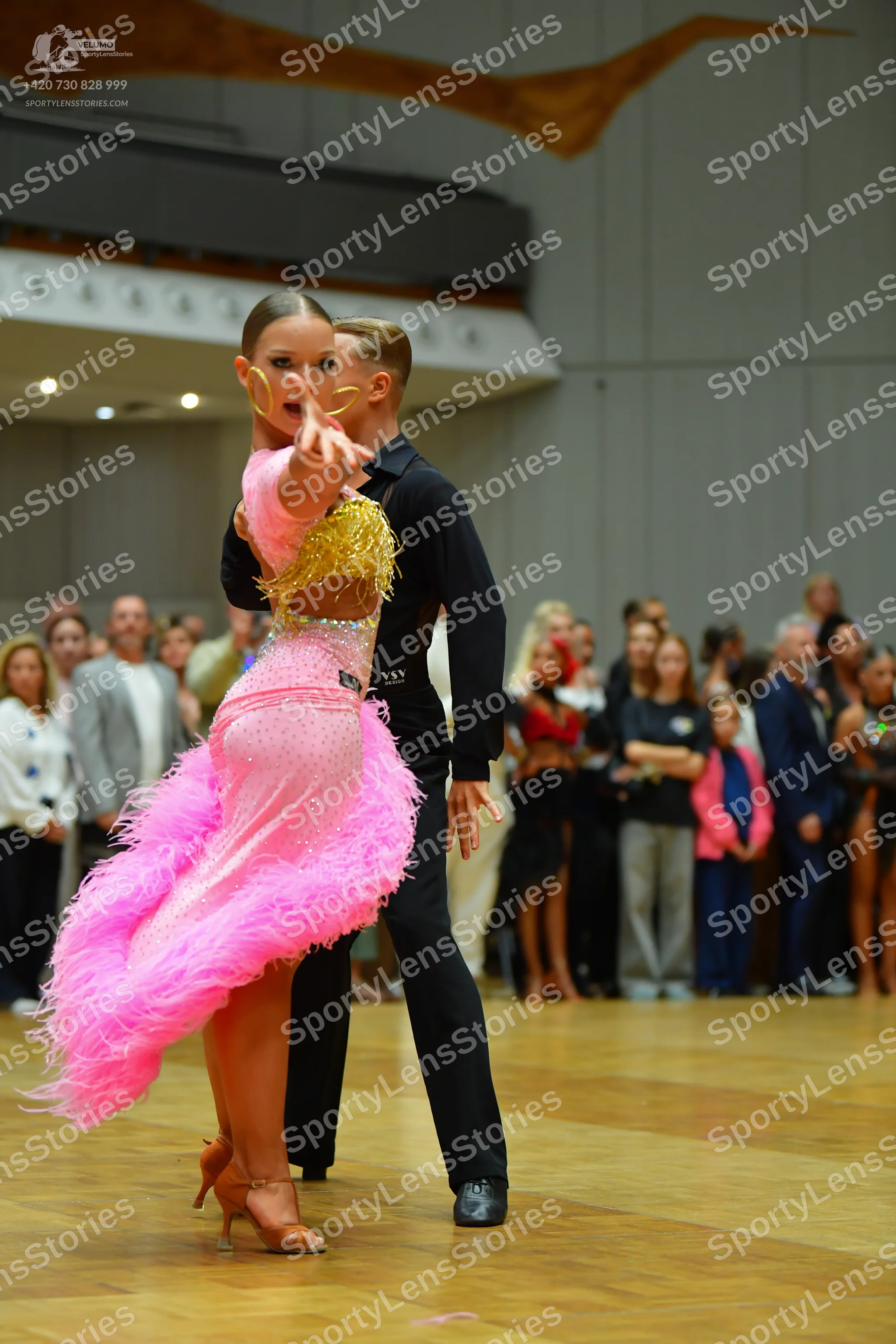 Dancesport competitor: Female dancer: pink latin dress with a gold sequined bodice and a skirt made of 