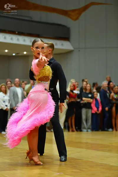Dancesport competitor: Female dancer: pink latin dress with a gold sequined bodice and a skirt made of 