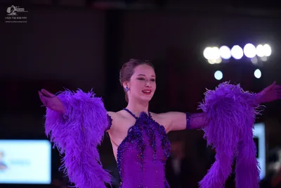 Dancesport competitor: Female dancer: purple latin dress with sequins, embellishments, and large purple