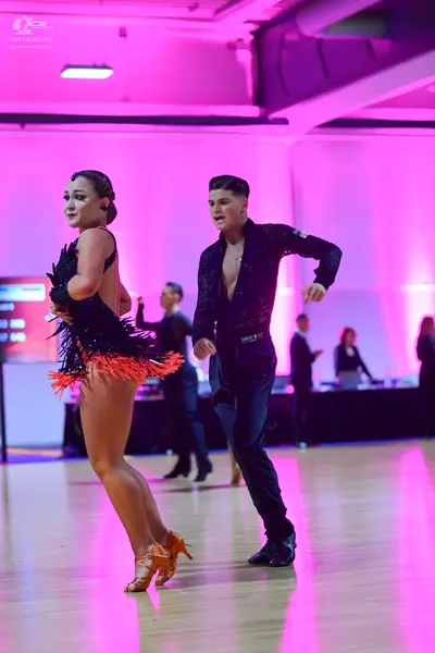 Dancesport competitor: Female dancer: black latin dress with orange fringe
