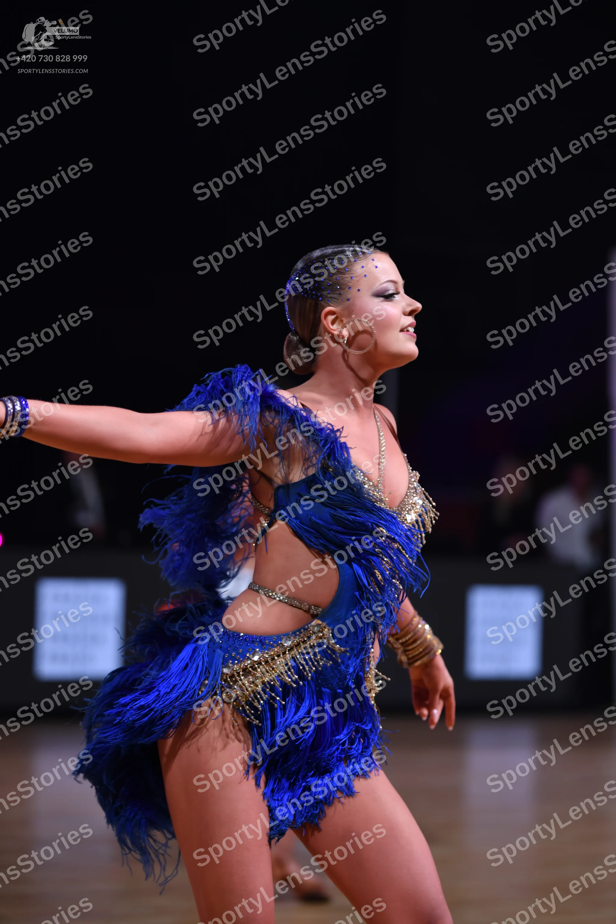 Dancesport competitor: Female dancer: royal blue Latin dance costume with blue fringe, gold sequin embe