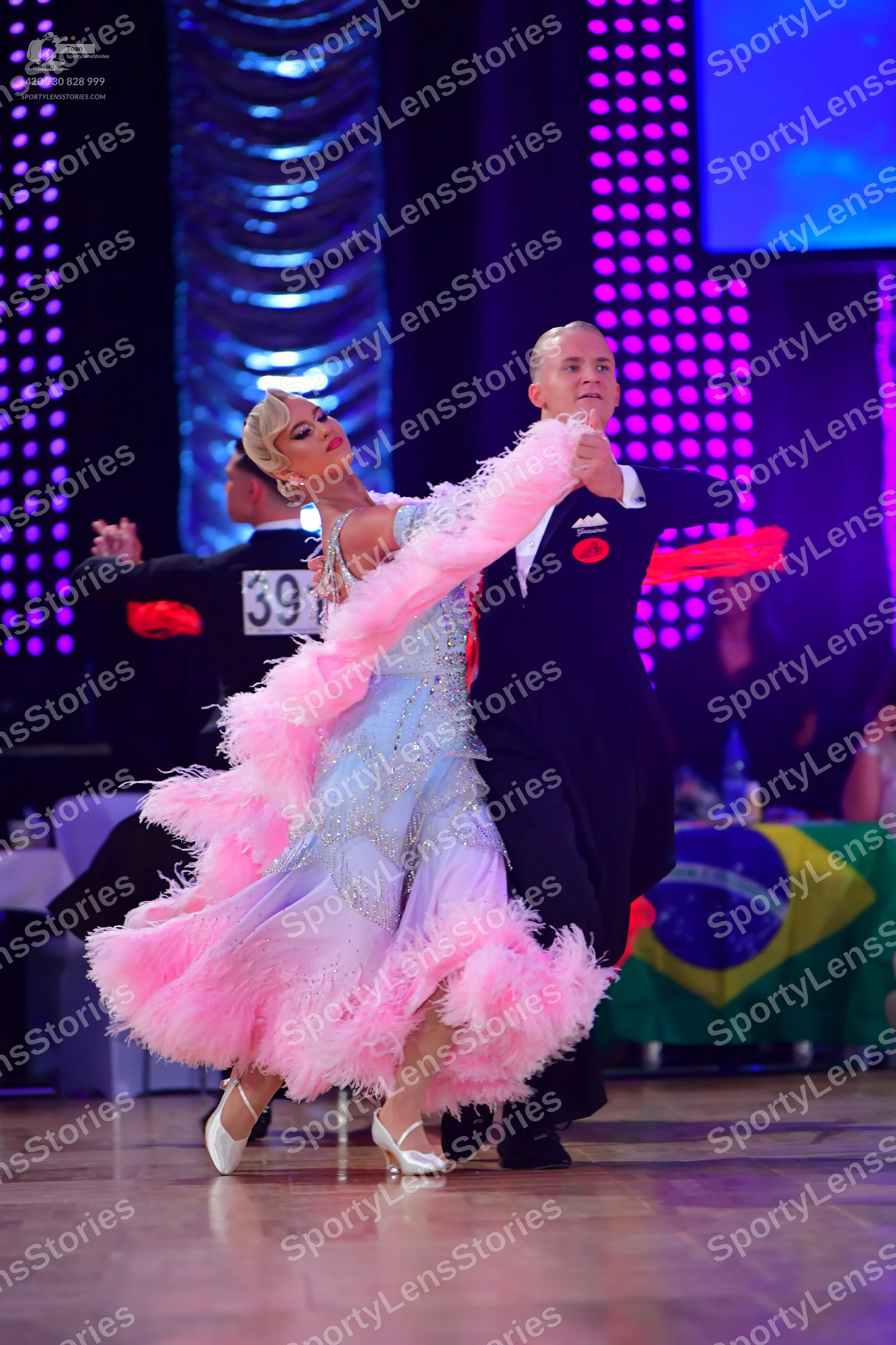 Dancesport competitor #391: Female dancer: light blue ballroom gown with a voluminous pink feathered skirt a