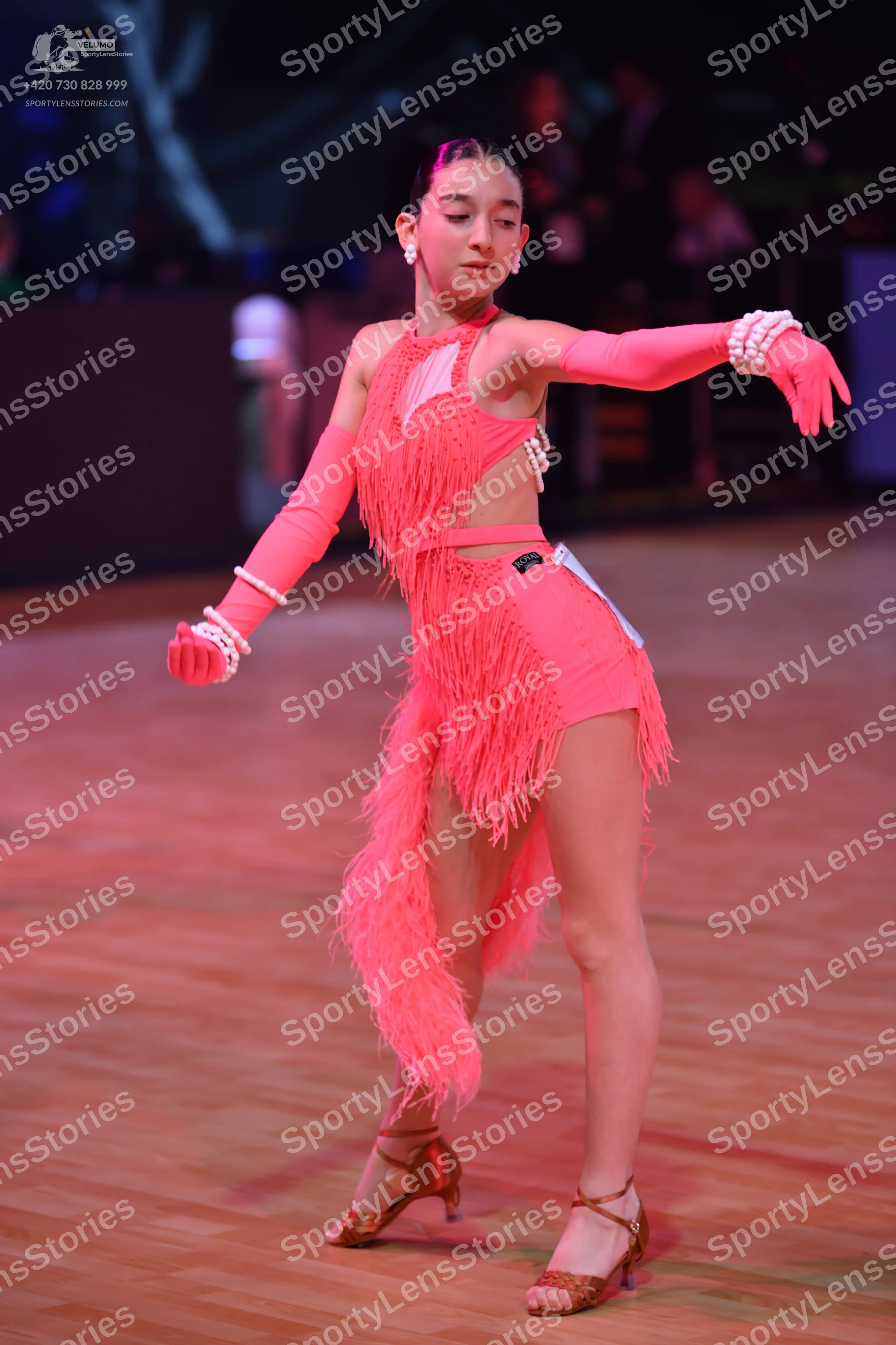 Dancesport competitor: Female dancer: pink Latin dance dress with long fringe, white/silver sequin trim