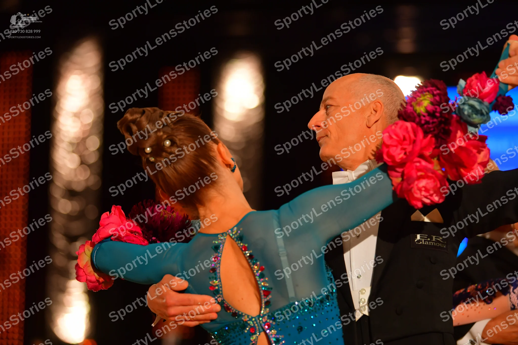 Dancesport competitor: Female dancer: teal long-sleeved Latin dress with a cutout on the back, embellis