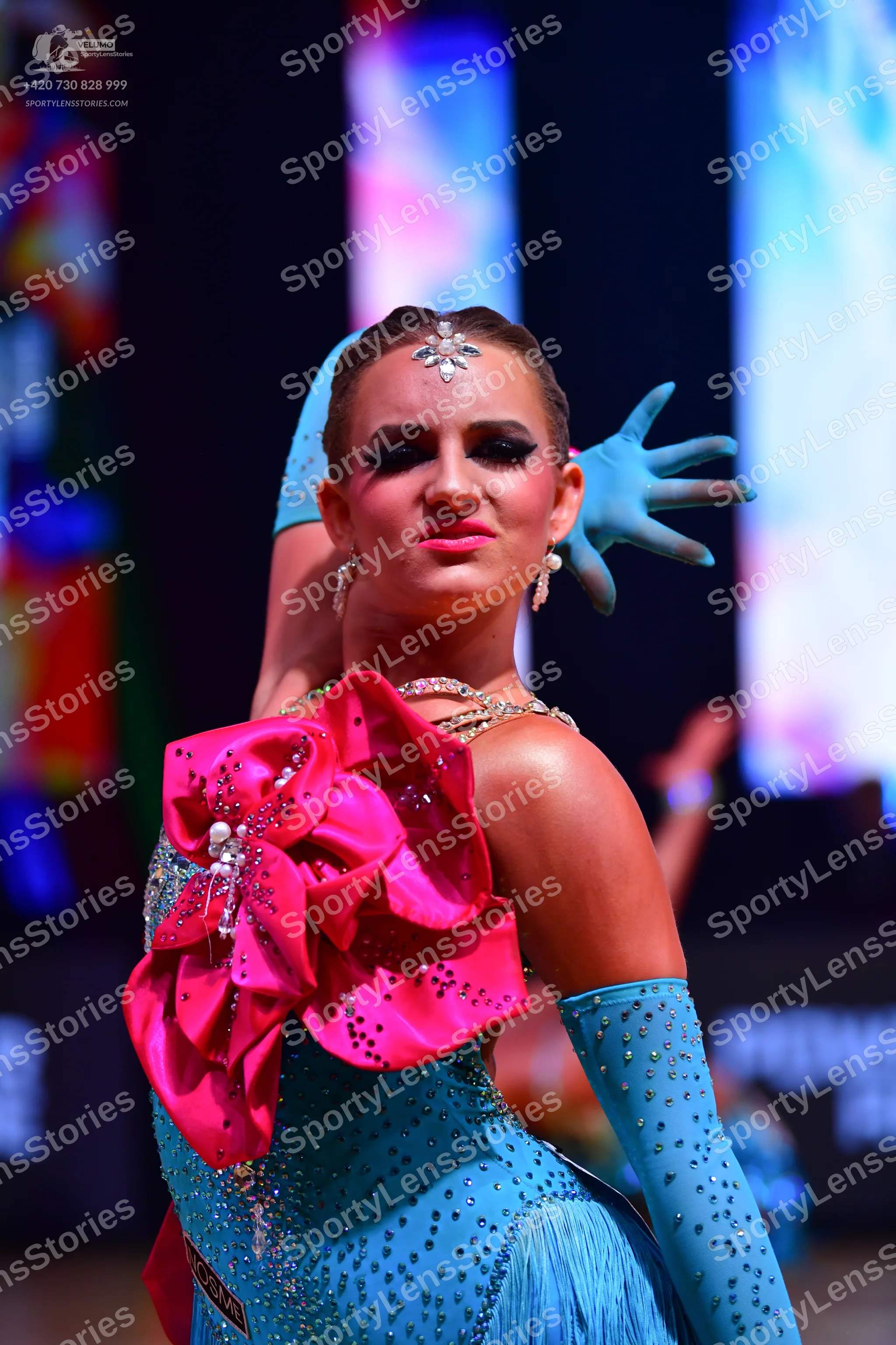 Dancesport competitor: Female dancer: light blue sequined latin dress with a large pink sequined flower