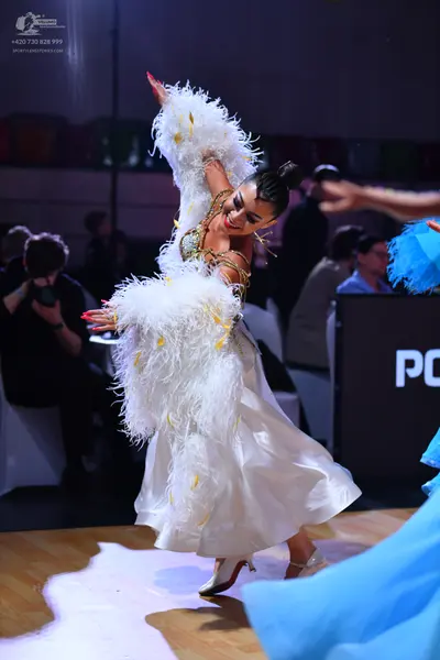 Dancesport competitor: Female dancer: white ballgown with voluminous white feather trim on the sleeves 
