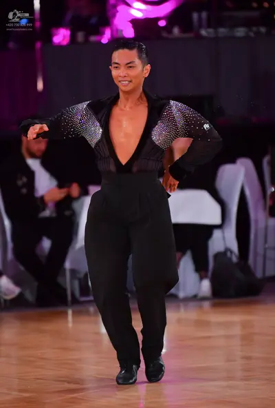 Dancesport competitor: Male dancer: black, long-sleeved, deep V-neck top with silver sequins on the sle