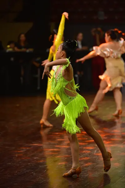 Dancesport competitor: Female dancer 1: lime green Latin dress with heavy fringe