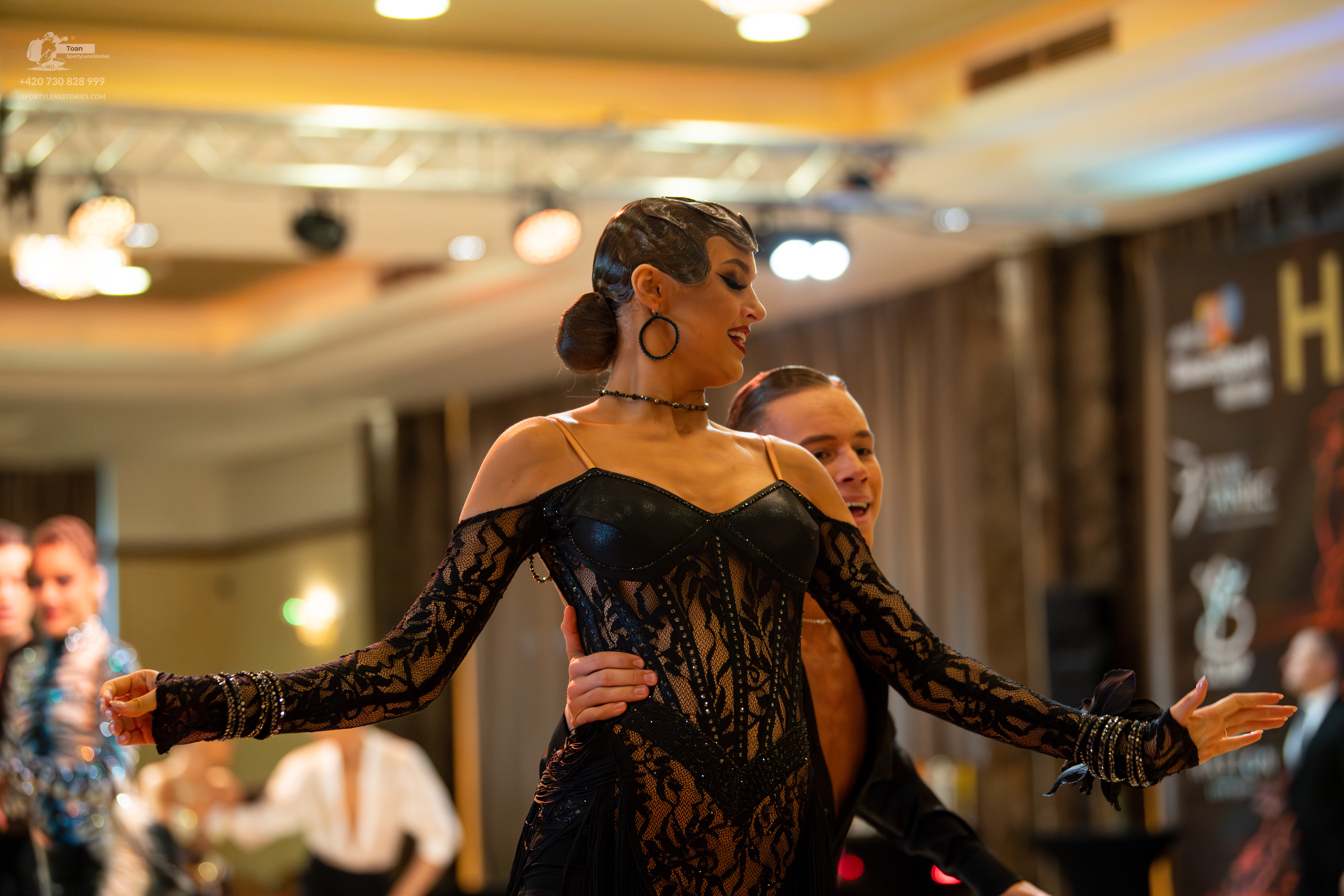 Dancesport competitor: Female dancer: black off-the-shoulder long-sleeve dress made of lace and solid f