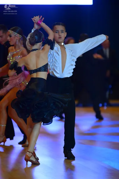 Dancesport competitor: Male dancer: white long-sleeved shirt with ruffles on the front and black trouse