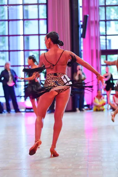 Dancesport competitor: Main dancer: leopard print latin costume with black fringe and thin black straps