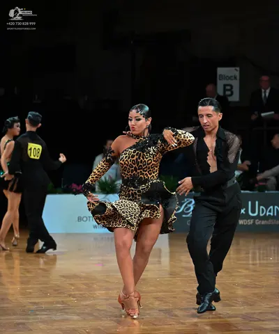 Dancesport competitor: Female dancer in center: leopard print Latin dress with long sleeves and black l
