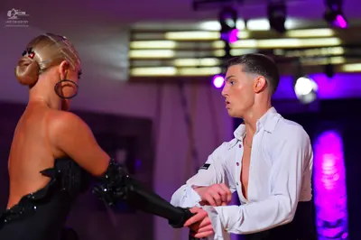 Dancesport competitor: Female dancer: black strapless dress with sparkling embellishments and large hoo