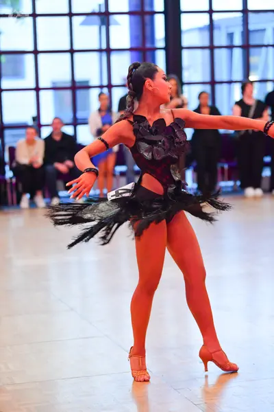 Dancesport competitor #14: Female dancer: black Latin dance dress with a textured, possibly sequined bodice