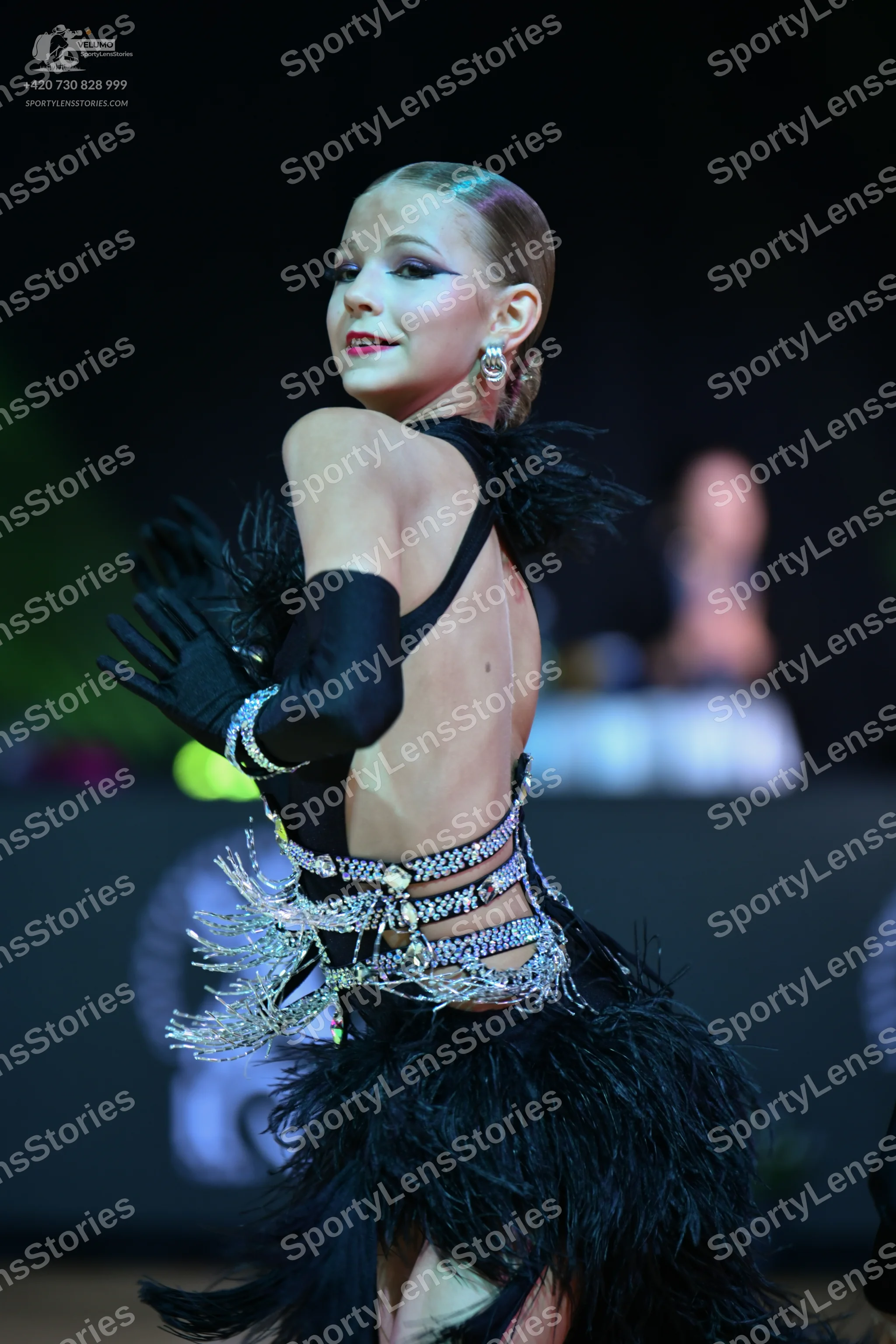 Dancesport competitor: Female dancer: black latin dance costume featuring a backless design, long black