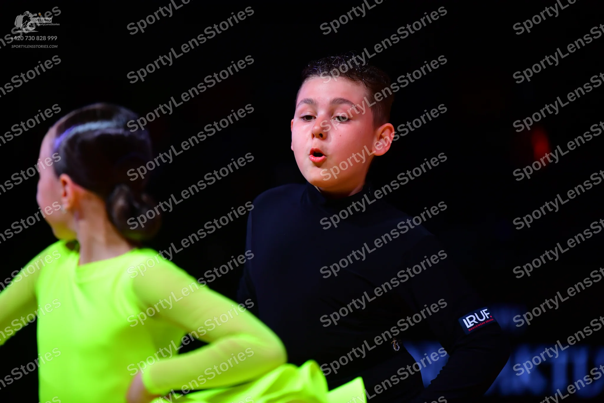 Dancesport competitor: Female dancer: neon green long-sleeved dress