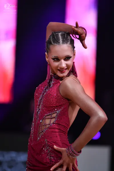 Dancesport competitor: Female dancer: burgundy Latin dress with sparkling embellishments and side cut-o
