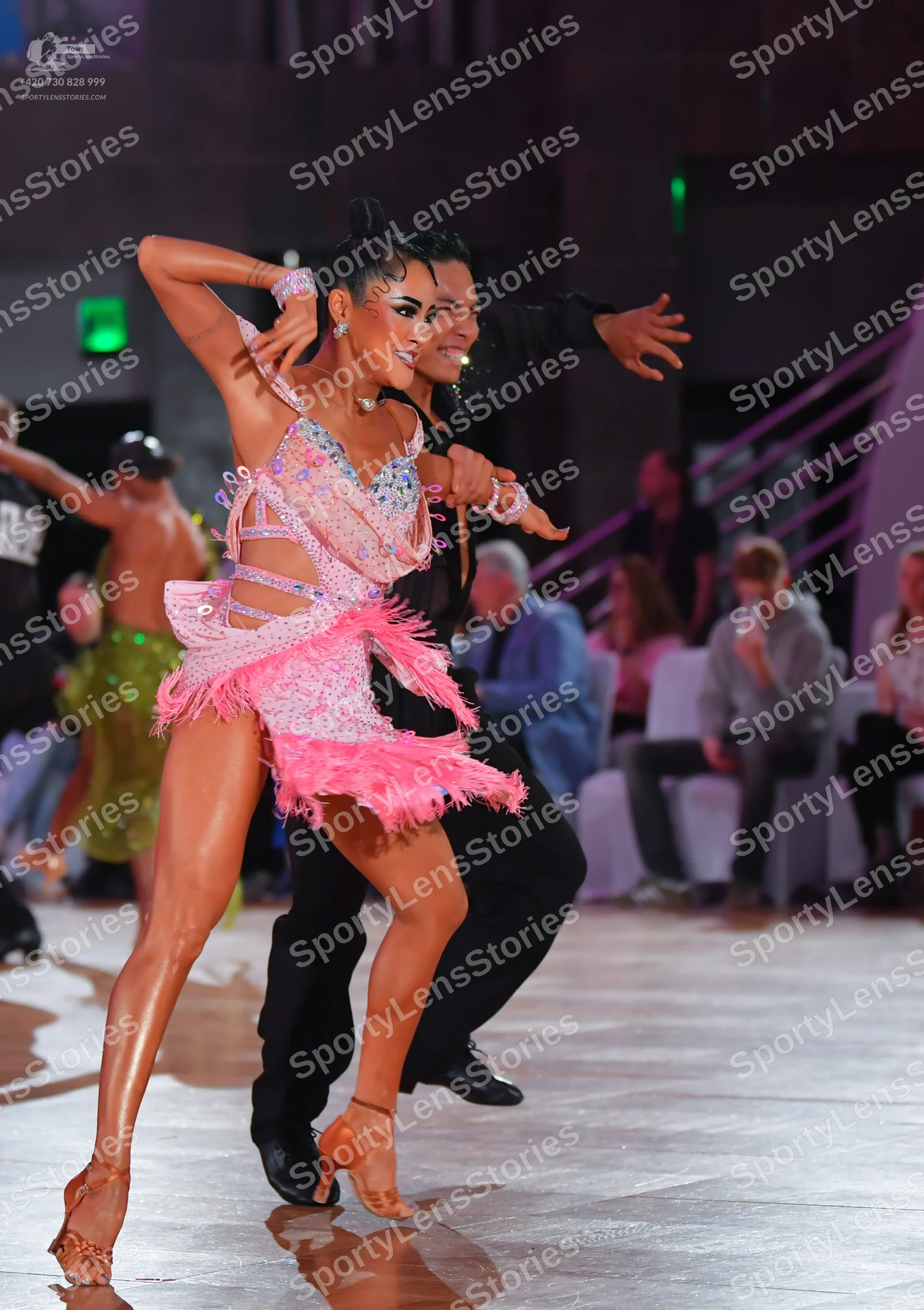 Dancesport competitor: Female dancer: light pink sequined Latin dress with a long pink feather-like fri