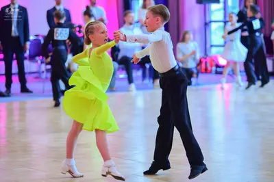 Dancesport competitor #668, #52: Foreground male dancer: white long-sleeved shirt and black trousers