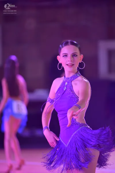 Dancesport competitor #145: Female dancer in foreground: purple Latin dress with rhinestone embellishments, 