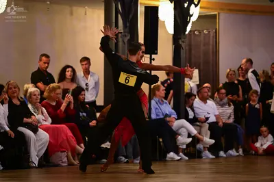 Dancesport competitor: Male dancer: black long-sleeve top and black trousers