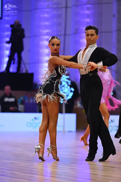 Dancesport competitor: Female dancer: black latin dress with silver sequins and long silver fringe, sil