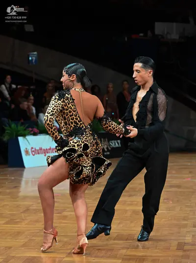 Dancesport competitor: Female dancer: leopard print latin dress with long sleeves and a flared skirt