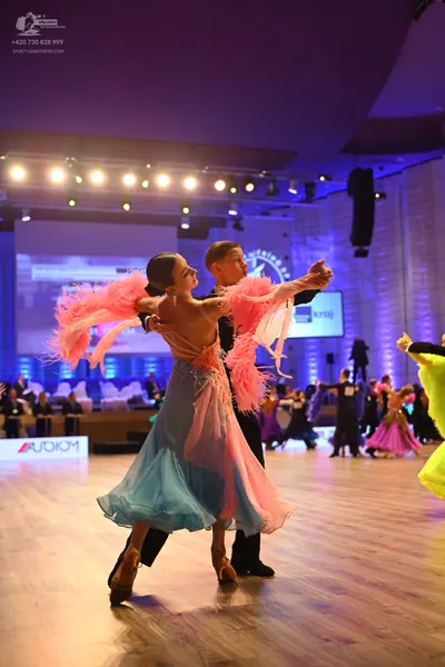 Dancesport competitor: Female dancer: light blue and pink Latin dress with voluminous pink feathered or
