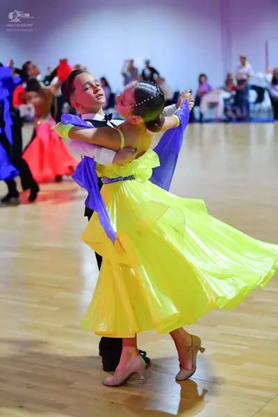 Dancesport competitor: Male dancer: white long-sleeved shirt with a black bow tie and black trousers